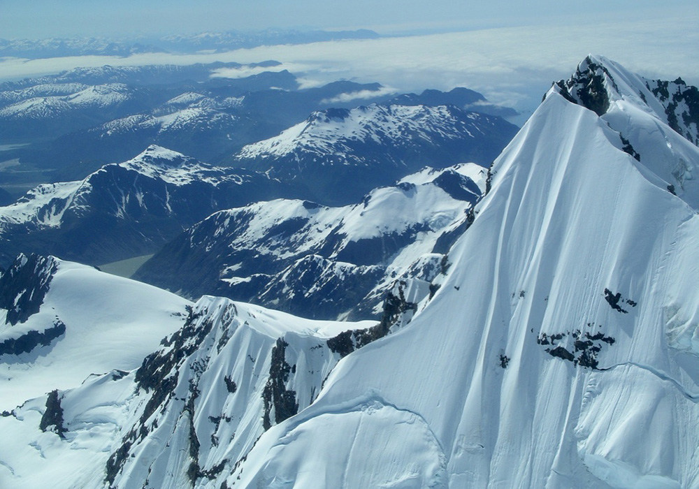 Peak of Mt. Crillon, Fairweather Range, Glacier Bay National Park, Alaska. Late June, early July. 2004. Note the two crevasse lines. Peak height—12, 726 feet/3,879 meters. A week later, these two crevasse lines collapsed. Alaska Airlines pilots flying over saw such clouds from the collapse they initially reported it as a volcano. Photograph by Abigail B. Calkin, 2004. Peak of Mt. Crillon, Fairweather Range, Glacier Bay National Park, Alaska. Late June, early July. 2004. Note the two crevasse lines. Peak height—12, 726 feet/3,879 meters. A week later, these two crevasse lines collapsed. Alaska Airlines pilots flying over saw such clouds from the collapse they initially reported it as a volcano. Photograph by Abigail B. Calkin, 2004.